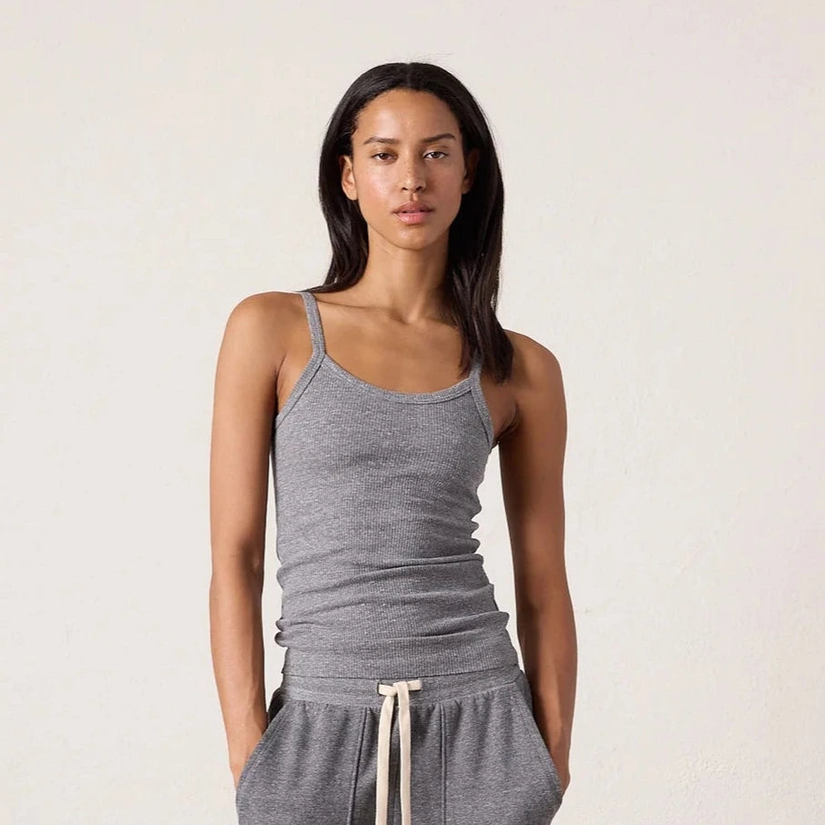 Woman wearing a gray tank top and matching pants against a plain background